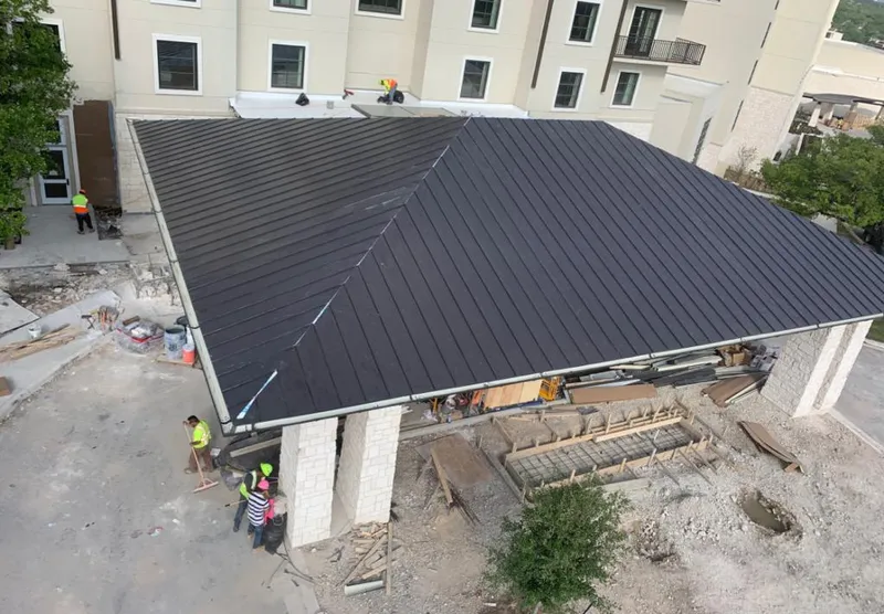 Metal roofing installation team working on a commercial building in Portsmouth